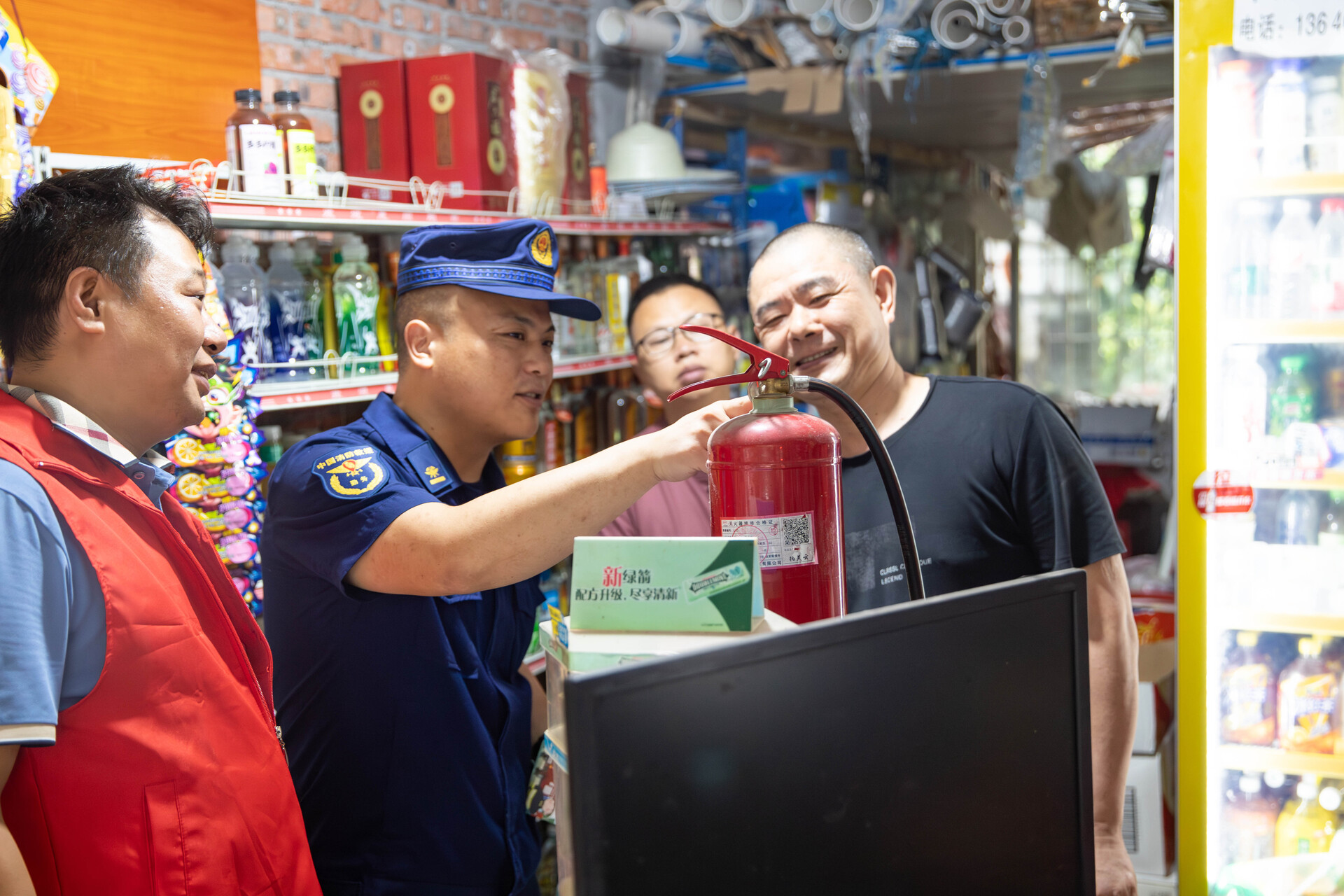 消防员指导沿街商户识别灭火器的正常压力值
