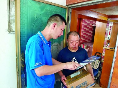 快递员入户时顺带向居民发放反诈宣传资料。重庆市委社会工作部供图