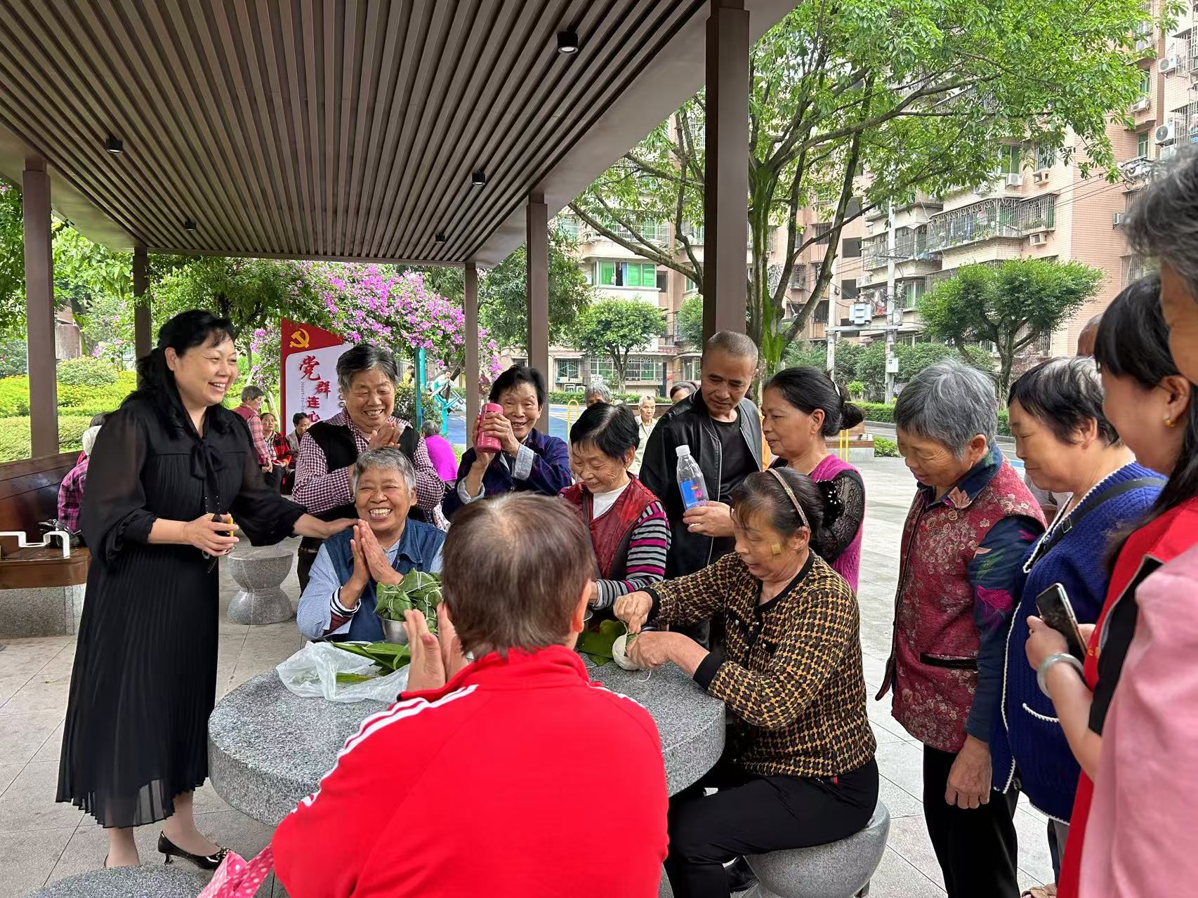 2024年6月3日,重庆市巴南区花溪街道先锋村村民聚在村里的“党建连心亭”包粽子、迎端午。图/王雪
