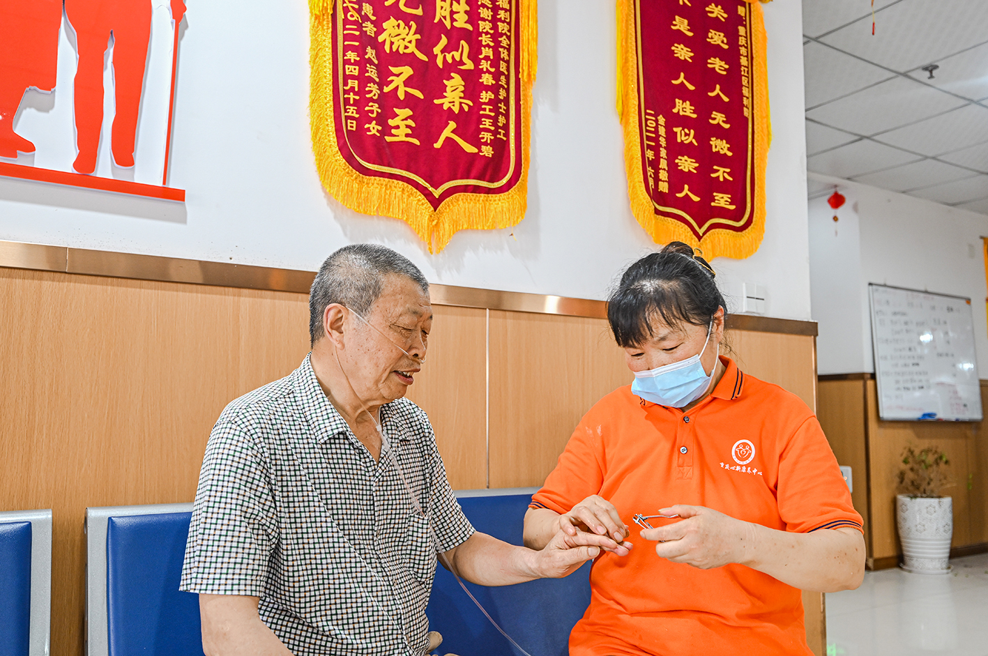 养老服务中心的护工为老人修剪指甲。图/万显芬