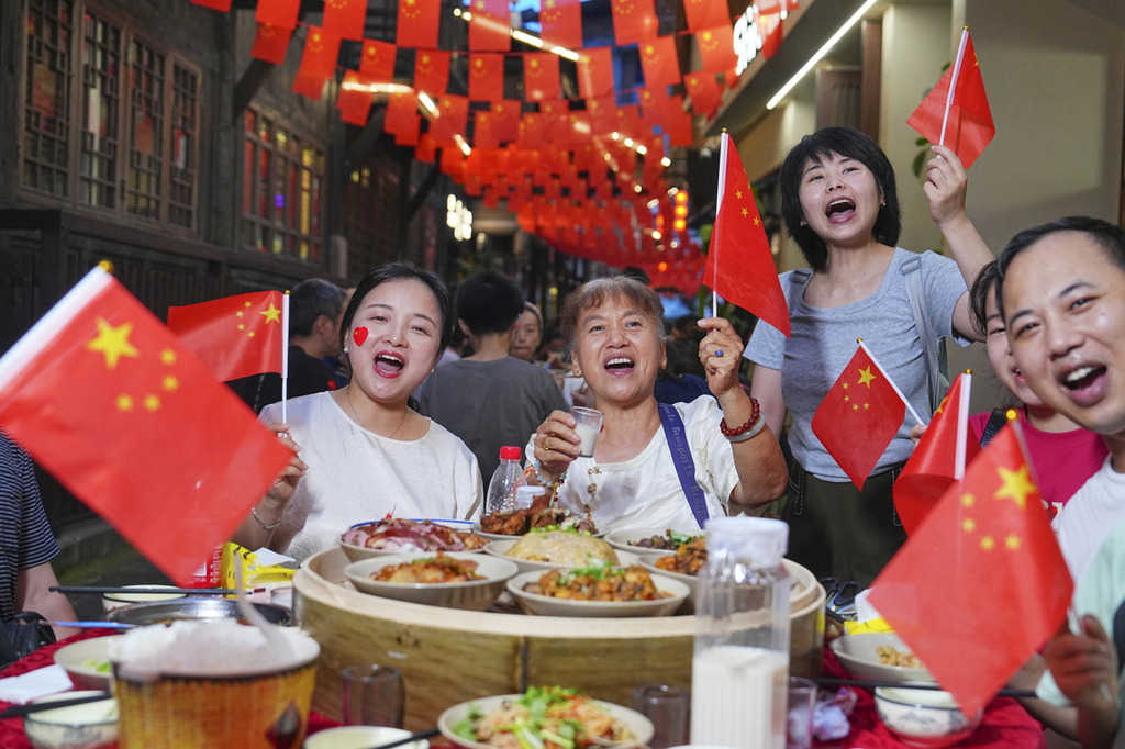 2025年10月1日晚,在重庆市北碚区金刀峡镇举行的“舌尖偏岩——长街夜宴”活动现场,游客在体验当地特色美食。秦廷富 摄