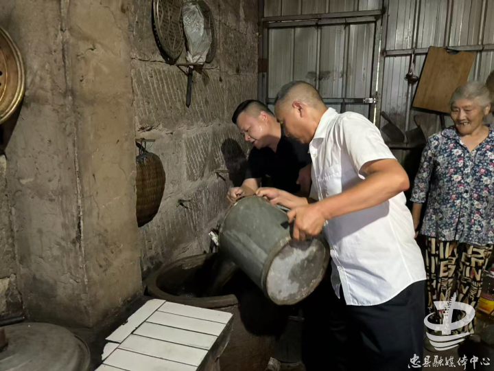 两河村驻村工作队和村委干部帮助村民送水担水。图/方世林