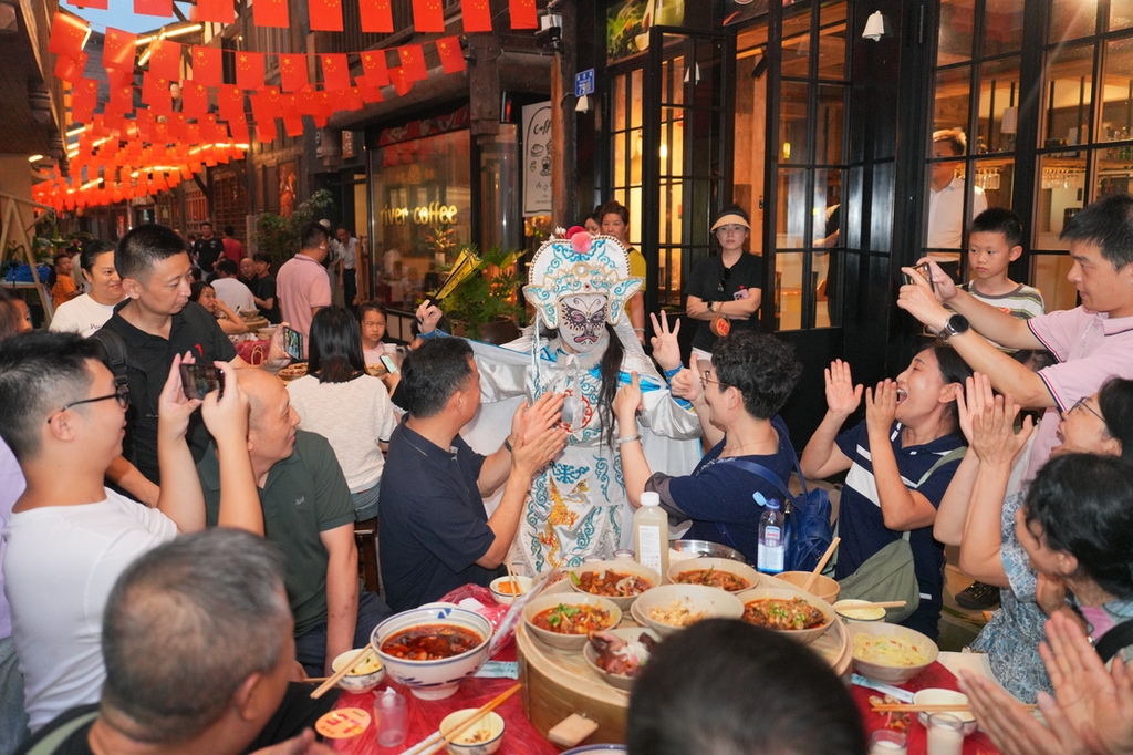 2025年10月6日晚,民间艺人在重庆市北碚区金刀峡镇偏岩古镇中秋长街宴上表演川剧变脸。秦廷富 摄