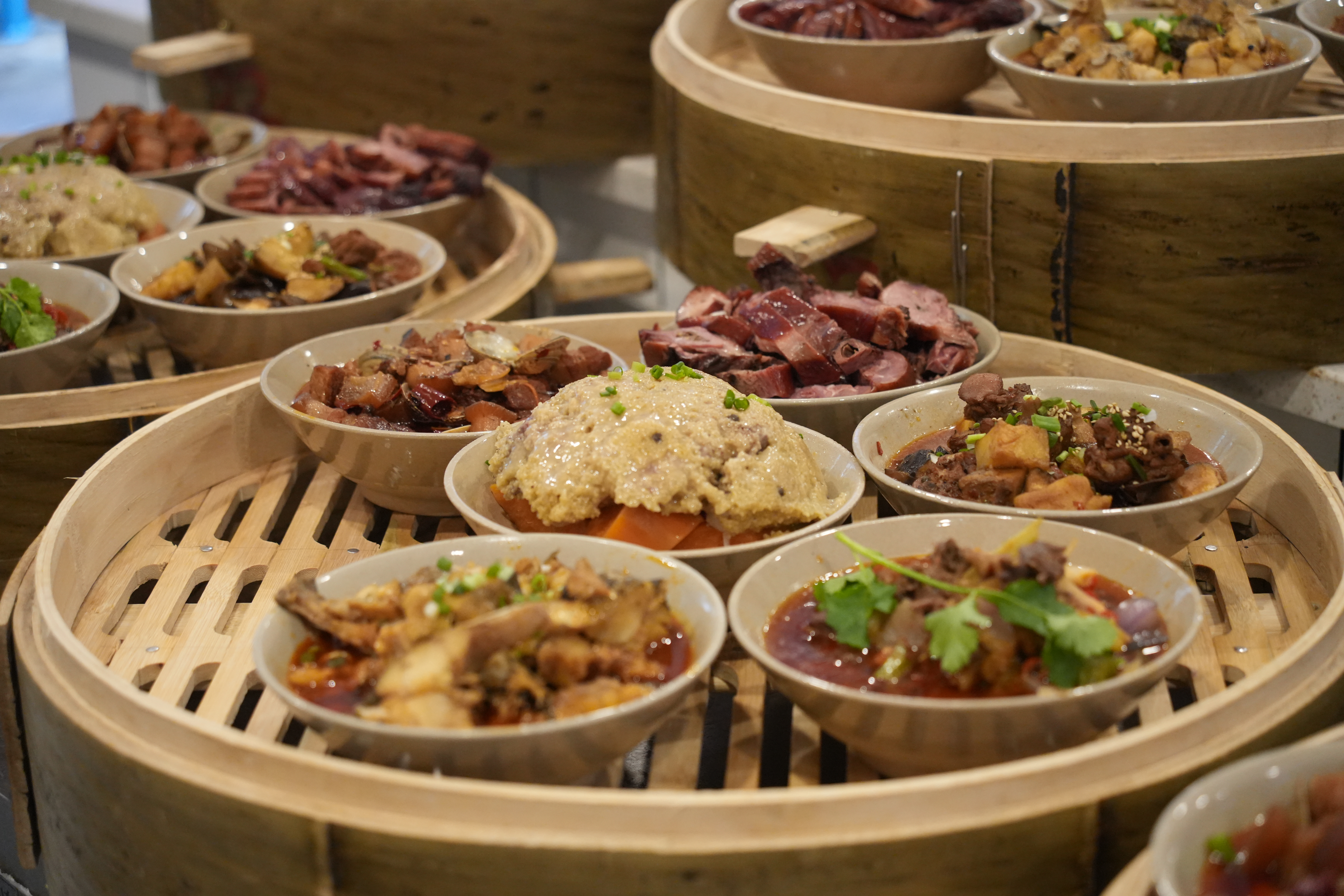 ▲放进竹笼内的当地特色菜品。新华社记者 田金文 摄