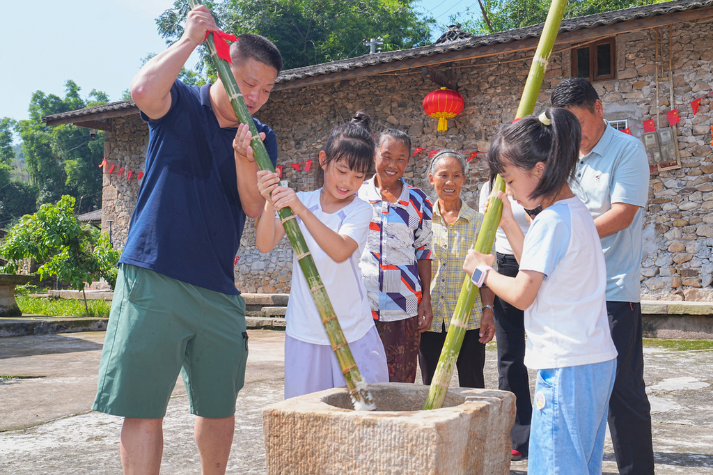 2025年10月6日,在重庆市北碚区金刀峡镇胜天湖村“九斗碗坝坝席”活动现场,游客在体验打糍粑。秦廷富 摄