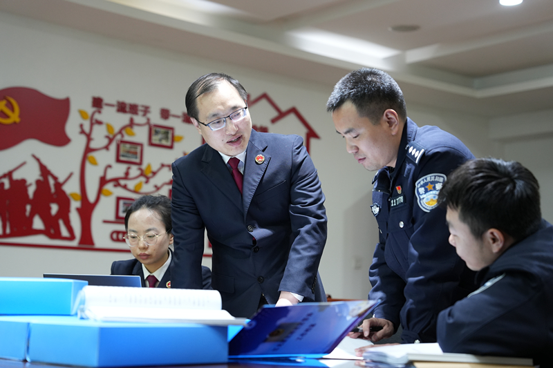 2025年3月17日,渝检护“未”团队代表吴波与万州区红光派出所民警讨论预防未成年人犯罪。重庆市人民检察院供图