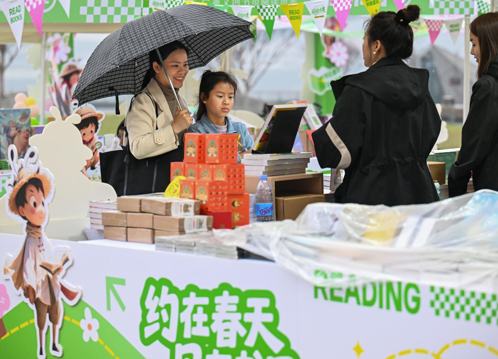 2026年3月14日，重庆金融会展中心广场，市民在“巴渝文创书市”阅读市集选购图书。张锦辉 摄