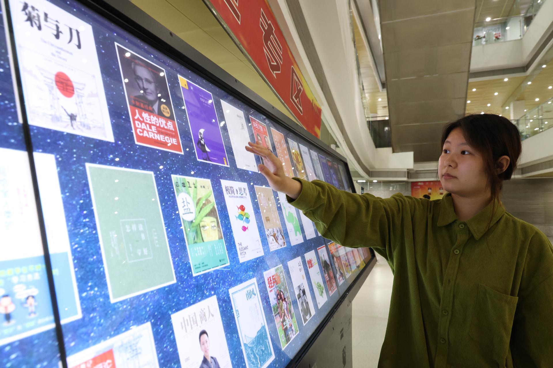 2026年4月8日，位于重庆市沙坪坝区的重庆图书馆，读者在数字阅读机上阅读数字图书。孙凯芳 摄